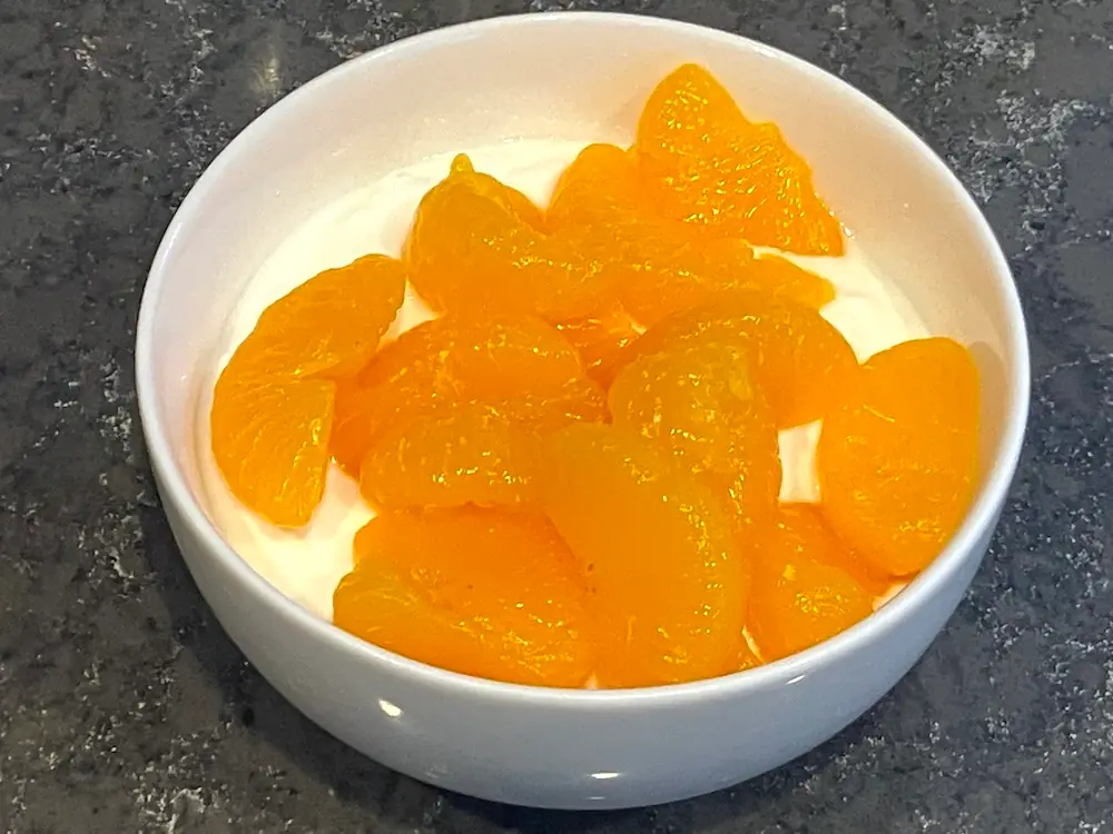 湯田ヨーグルトの食べ方：フルーツ（みかんの缶詰）を加えて食べているところ